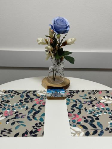 a blue flower in a vase on a table at Eleven in Podgorica