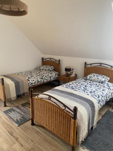 a bedroom with two beds and a rug at Zielnisko in Firlej