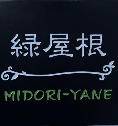a sign with chinese writing on a wall at 民泊みどりやね in Ibusuki