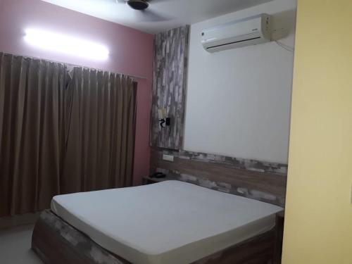 a bedroom with a white bed and a window at hotel sagnik in Murshidābād