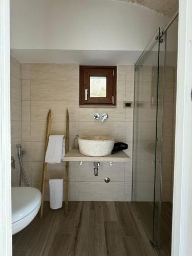 a bathroom with a sink and a glass shower at Le Casette di Ciccio in Fasano
