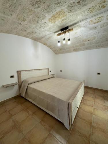 a bedroom with a large bed in a white room at Le Casette di Ciccio in Fasano