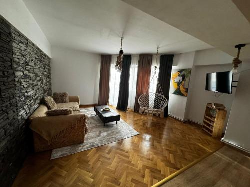a living room with a couch and a stone wall at Rosa Apartment in Drobeta-Turnu Severin