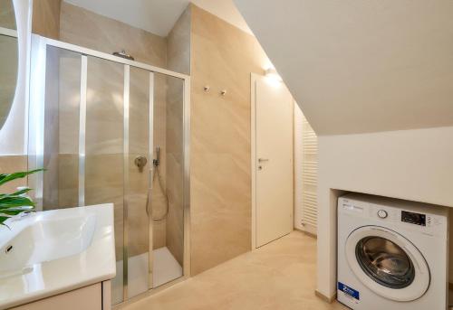 een badkamer met een wasmachine en een wastafel bij SISTERS' HOUSE in Varenna