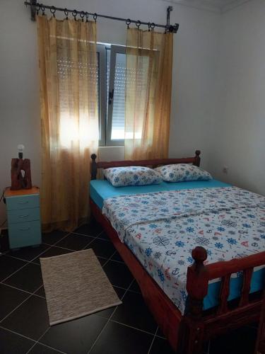 a bedroom with a bed and a window with curtains at Apartments ,,VIKTOR'' in Kruče