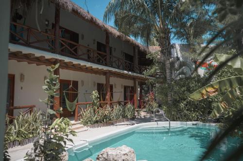 un hotel con piscina frente a un edificio en Casa Iguana Holbox - Beachfront Hotel en Holbox Island