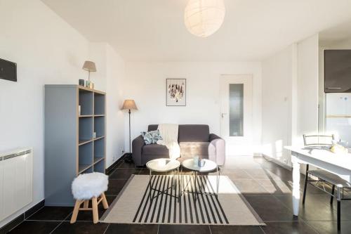 un salon avec un canapé et une table dans l'établissement Malo - Bulle d'air proche plage 4 a 6 pers, à Dunkerque