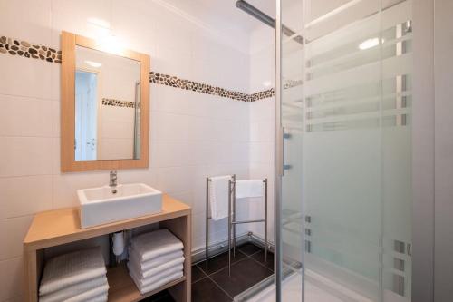 a bathroom with a sink and a glass shower at Malo - Bulle d'air proche plage 4 a 6 pers in Dunkerque
