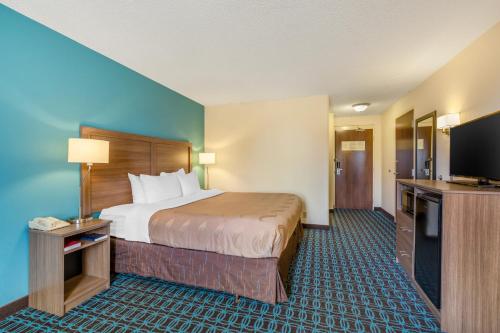 a hotel room with a bed and a flat screen tv at Quality Inn & Suites Sandusky in Sandusky