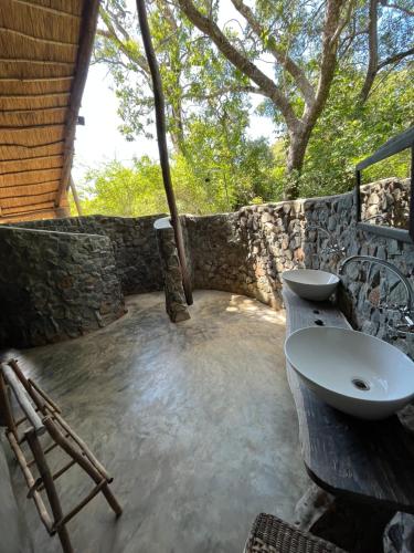 uma casa de banho com um lavatório e uma parede de pedra em Bua River Lodge 