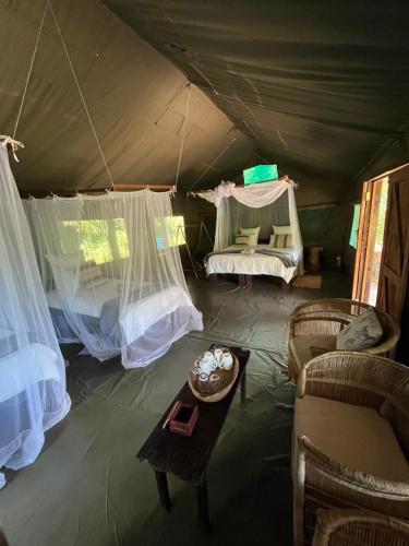 um quarto com uma tenda com uma mesa e cadeiras em Bua River Lodge 