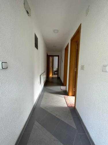 an empty hallway with white walls and a hallway with doors at Riverstone Retreat Villa in Jajce