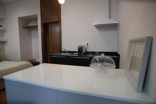 a kitchen with a white counter top with a sink at Nidos Accommodation Gaia in Vila Nova de Gaia