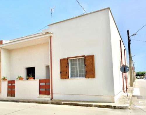 a white building with a window on a street at Casa Vacanze Patrizia in Botrugno