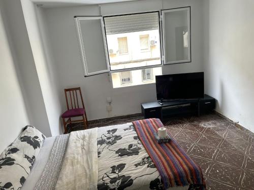 a bedroom with a bed and a flat screen tv at Habitación grande y comoda en piso particular y familiar in Valencia