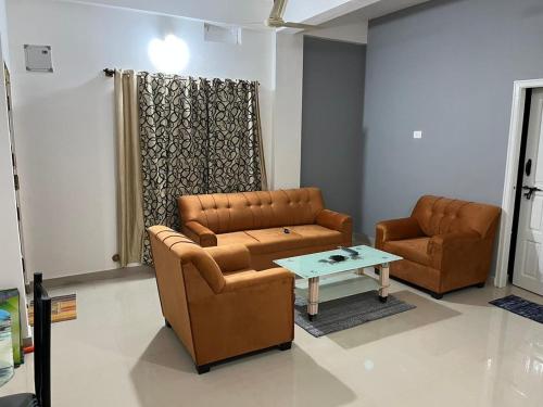a living room with two leather chairs and a table at Universal family stay in Chikmagalūr