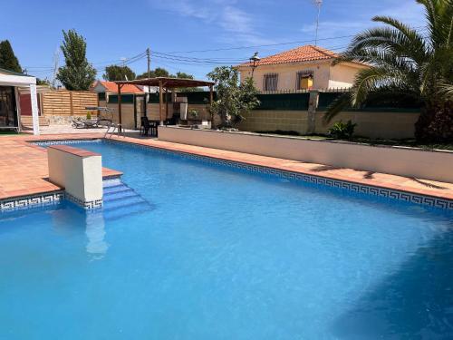 a large blue swimming pool in front of a house at La Casita de Yuncos in Yuncos