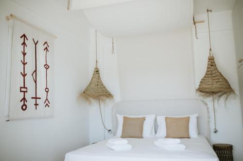 ein Schlafzimmer mit einem weißen Bett mit zwei Kissen in der Unterkunft Aloe Comfort House by KHI in Kythnos
