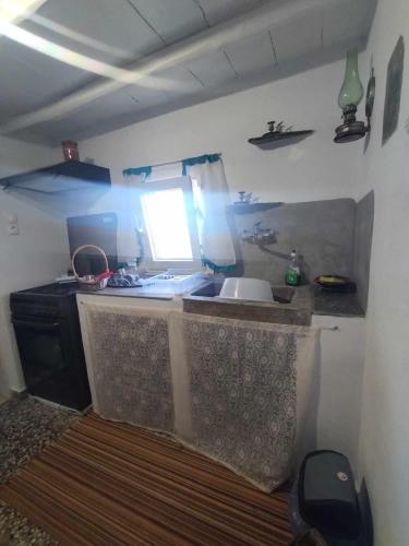 a kitchen with a counter with a sink and a window at Smaragda home in Liaropá