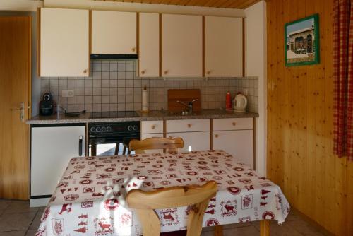 a kitchen with a table with a red and white table cloth at Waldruhe in Jaun