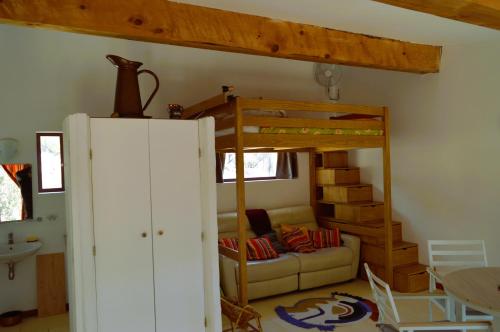 un salon avec un lit superposé et un canapé dans l'établissement Ailleursland, à Montalba-le-Château