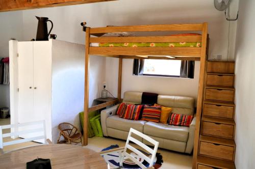 un salon avec un lit superposé et un canapé dans l'établissement Ailleursland, à Montalba-le-Château