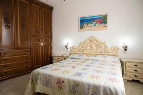 a bedroom with a bed and wooden cabinets at Appartamento Il Veliero Vista Darsena in Portoferraio