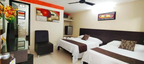 a hotel room with two beds and a tv at Hotel San Miguel in Progreso