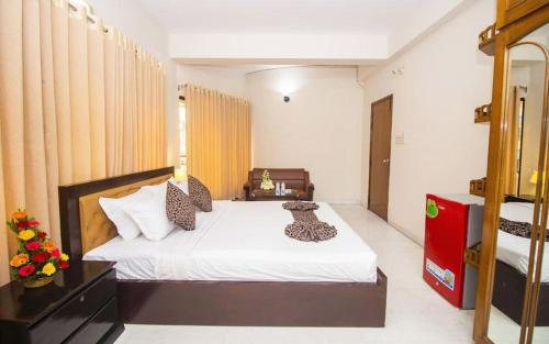 a bedroom with a white bed with leopard pillows at Hotel Suite Palace Baridhara in Dhaka