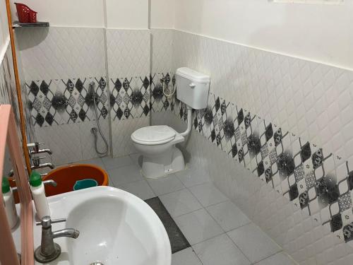 a bathroom with a toilet and a sink at Universal family stay in Chikmagalūr