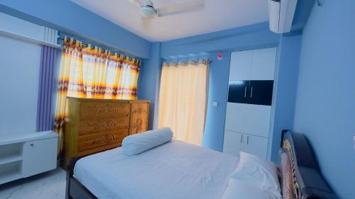 ein blaues Schlafzimmer mit einem Bett und einem Fenster in der Unterkunft Baridhara Sweet Home in Dhaka
