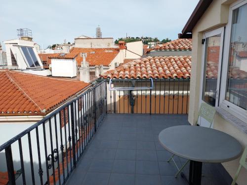 a balcony with a table and a view of roofs at App Antonija in Piran