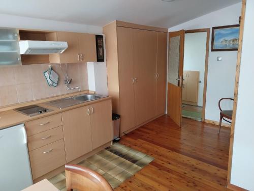 a kitchen with wooden cabinets and a wooden floor at App Antonija in Piran