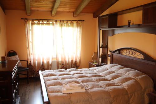een slaapkamer met een groot bed en een raam bij B&B Morena in Cormòns