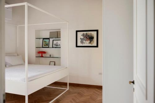 Cette chambre blanche comprend un lit et un miroir. dans l'établissement Posillipo 70 Napoli, à Naples