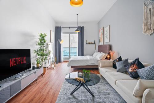 a living room with a couch and a tv at Stylish studio at Sports City in Dubai