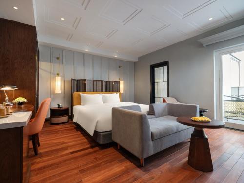 a hotel room with a bed and a couch at Minerva Premium Hotel in Hanoi