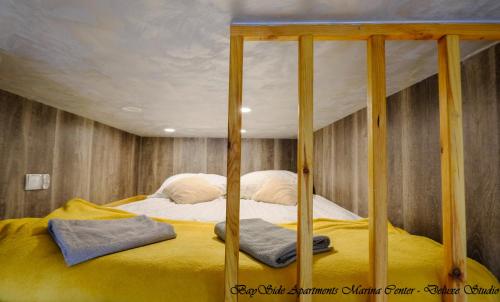 Cama con dosel con sábanas amarillas y almohadas en BaySide Apartments Marina Center en Gdansk