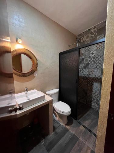 La salle de bains est pourvue de toilettes, d'un lavabo et d'une douche. dans l'établissement Grupo Kan, à Valladolid