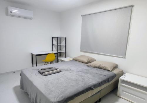 - une chambre avec un lit, un bureau et une chaise jaune dans l'établissement Village Novo Barra do Jacuípe, à Camaçari