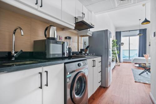 a kitchen with a washer and dryer in it at Stylish studio at Sports City in Dubai