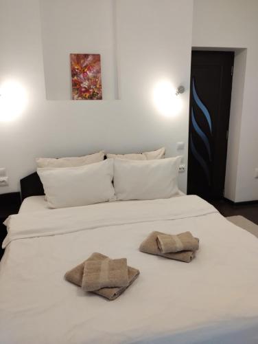 a large white bed with two towels on it at Casa cu Flori in Buşteni