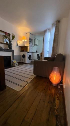 - un salon avec un canapé et une table avec une lampe dans l'établissement APPARTEMENT*GARE DE L'EST-PARIS 10, à Paris