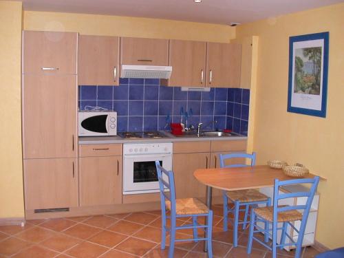 une cuisine avec une table et des chaises et un micro-ondes dans l'établissement Studio Festival 1, à Avignon