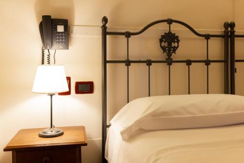 a bedroom with a bed with a phone on the wall at Locanda Del Mulino in Maranello