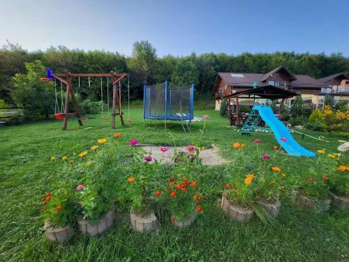 um jardim com um parque infantil e um baloiço em Dumbrava Ursului em Zarnesti