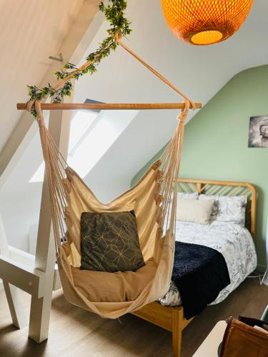 a hammock swing in a bedroom with a bed at Le studio d'Angèle : KIMI in Bruz