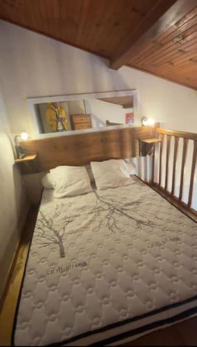 une chambre avec un lit avec une tête de lit en bois dans l'établissement Appartement curistes, à Cazaubon