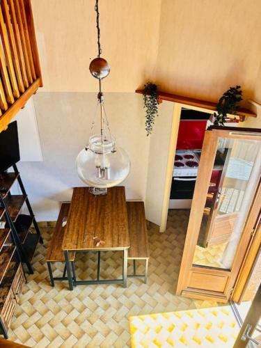 un salon avec une table et un lustre dans l'établissement Appartement curistes, à Cazaubon