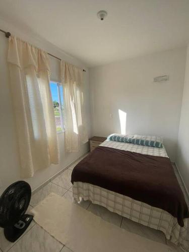 a bedroom with a bed and a window at brisas da maré 101 in Passo de Torres